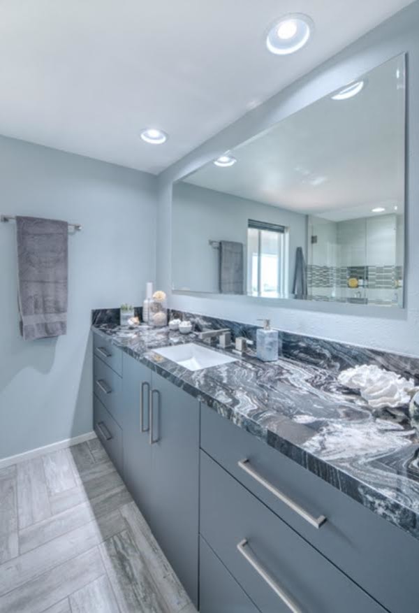 Photo of a mid-sized transitional bathroom in San Diego with beaded inset cabinets, grey cabinets, a shower/bathtub combo, porcelain tile, grey walls, porcelain floors, an undermount sink, concrete benchtops, grey floor and a hinged shower door.