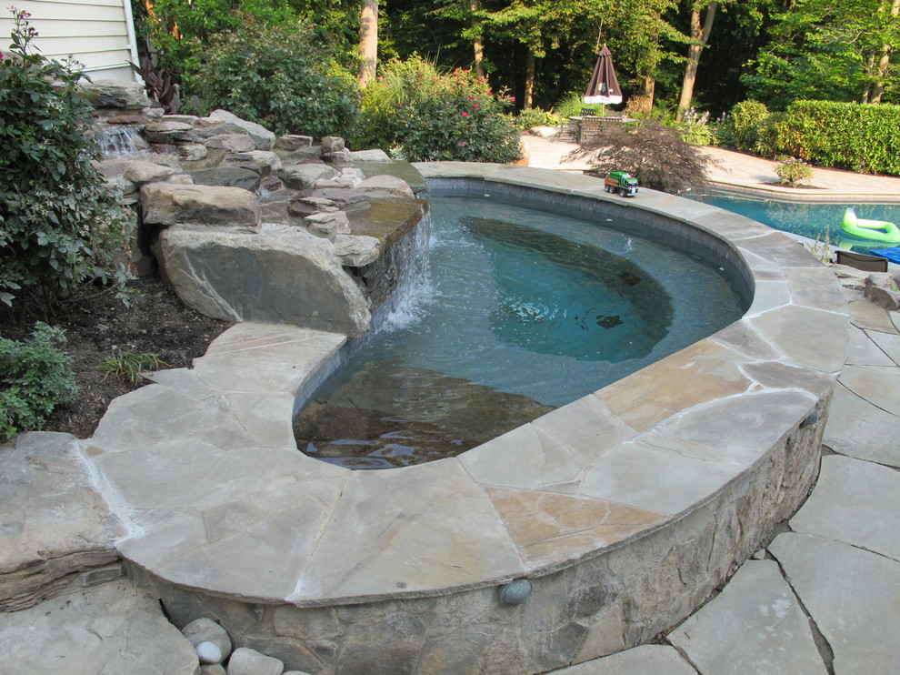 Inspiration for a mid-sized transitional backyard stone and custom-shaped natural hot tub remodel in Baltimore