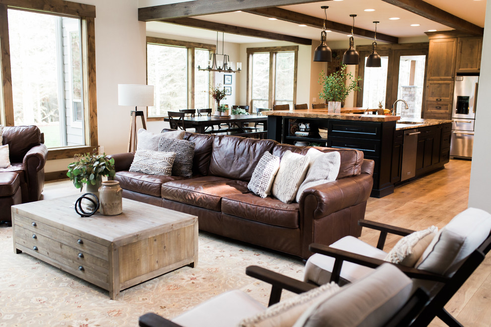 Design ideas for a large country formal open concept living room in Seattle with brown walls, light hardwood floors, a standard fireplace, a stone fireplace surround, a built-in media wall and brown floor.