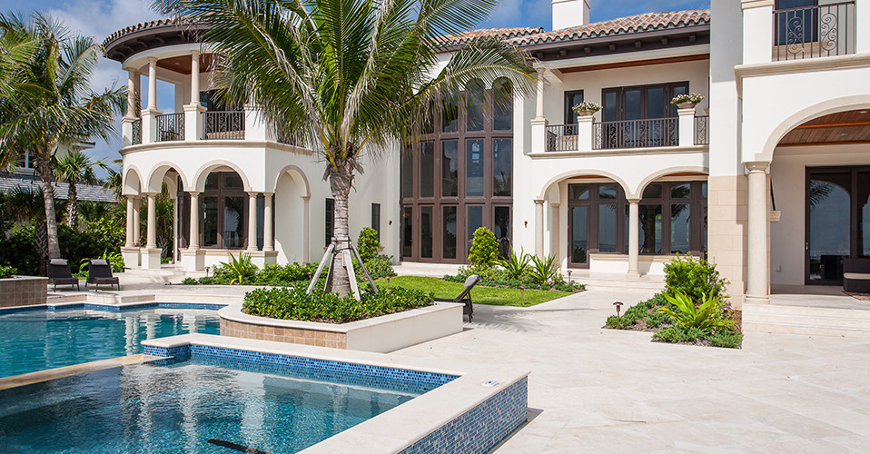 Photo of a large mediterranean backyard custom-shaped pool in Miami with a hot tub and tile.
