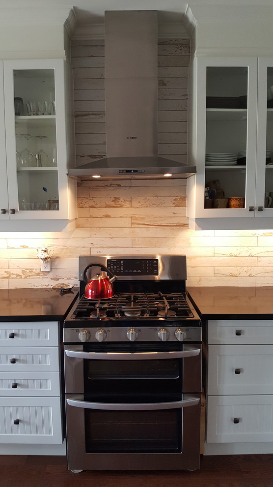 Mid-sized mountain style l-shaped medium tone wood floor and brown floor open concept kitchen photo with an undermount sink, shaker cabinets, white cabinets, quartz countertops, multicolored backsplash, porcelain backsplash, stainless steel appliances and a peninsula