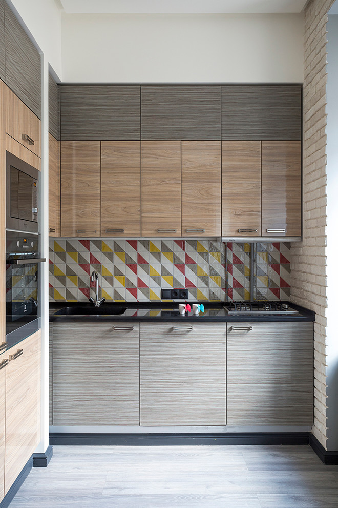 Photo of a small l-shaped eat-in kitchen in Moscow with an integrated sink, flat-panel cabinets, quartz benchtops, multi-coloured splashback, terra-cotta splashback, stainless steel appliances, laminate floors and no island.