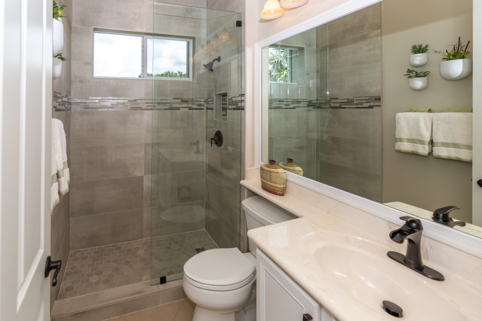 Photo of a small transitional 3/4 bathroom in Miami with recessed-panel cabinets, white cabinets, an open shower, a two-piece toilet, beige tile, porcelain tile, beige walls, porcelain floors, an integrated sink, granite benchtops, beige floor, an open shower, beige benchtops, a niche, a single vanity and a built-in vanity.