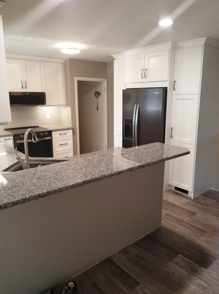 Example of a mid-sized transitional u-shaped gray floor eat-in kitchen design with an undermount sink, recessed-panel cabinets, white cabinets, granite countertops, black appliances and a peninsula