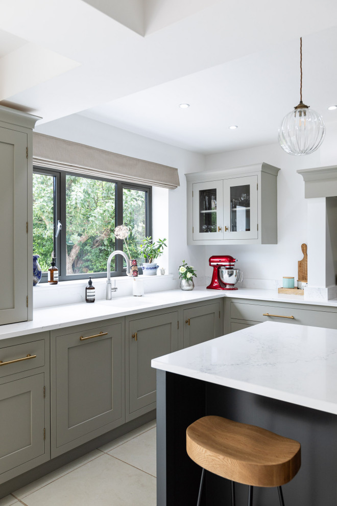 This is an example of an expansive traditional l-shaped eat-in kitchen in Hertfordshire with a single-bowl sink, raised-panel cabinets, grey cabinets, quartzite benchtops, metallic splashback, mirror splashback, limestone floors, with island, white floor and white benchtop.