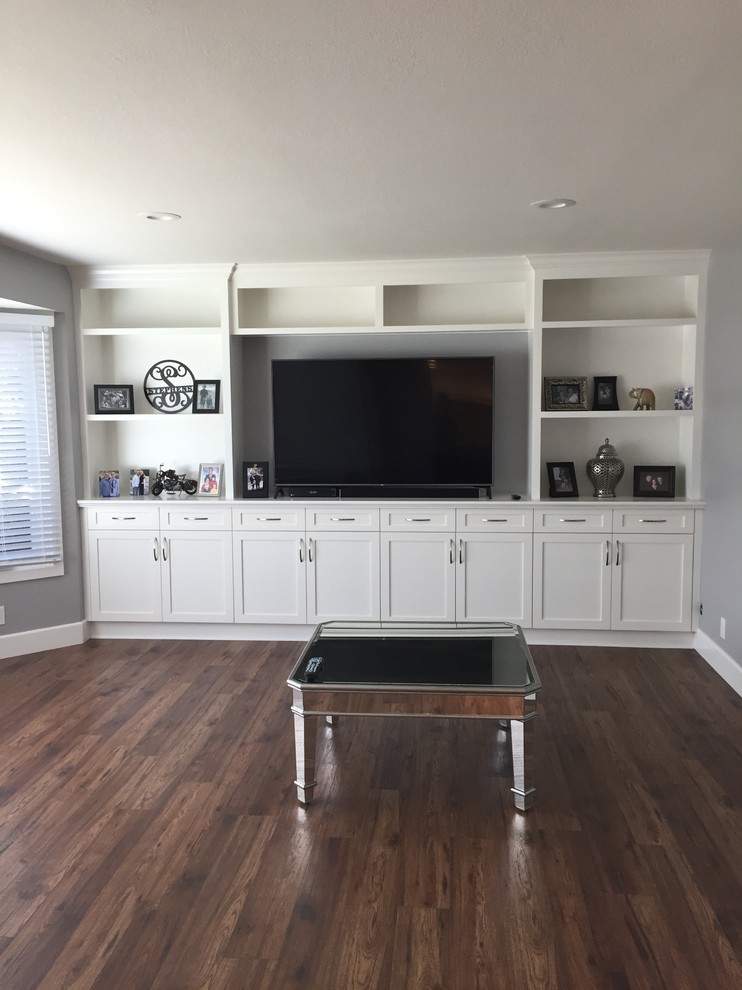 This is an example of a transitional family room in Orange County with grey walls and brown floor.