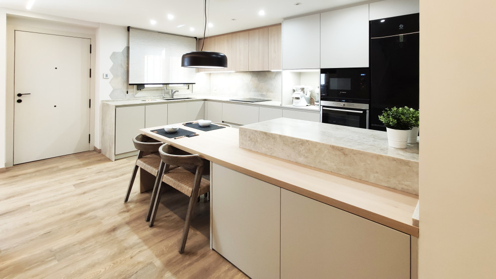 Diseño de cocinas en L contemporánea de tamaño medio abierta con armarios con paneles lisos, encimera de mármol, salpicadero con mosaicos de azulejos, electrodomésticos negros y península