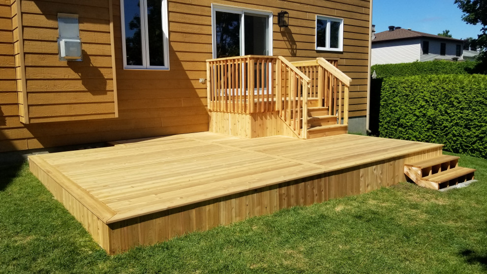 Medium sized modern back ground level wood railing terrace in Ottawa with skirting and no cover.