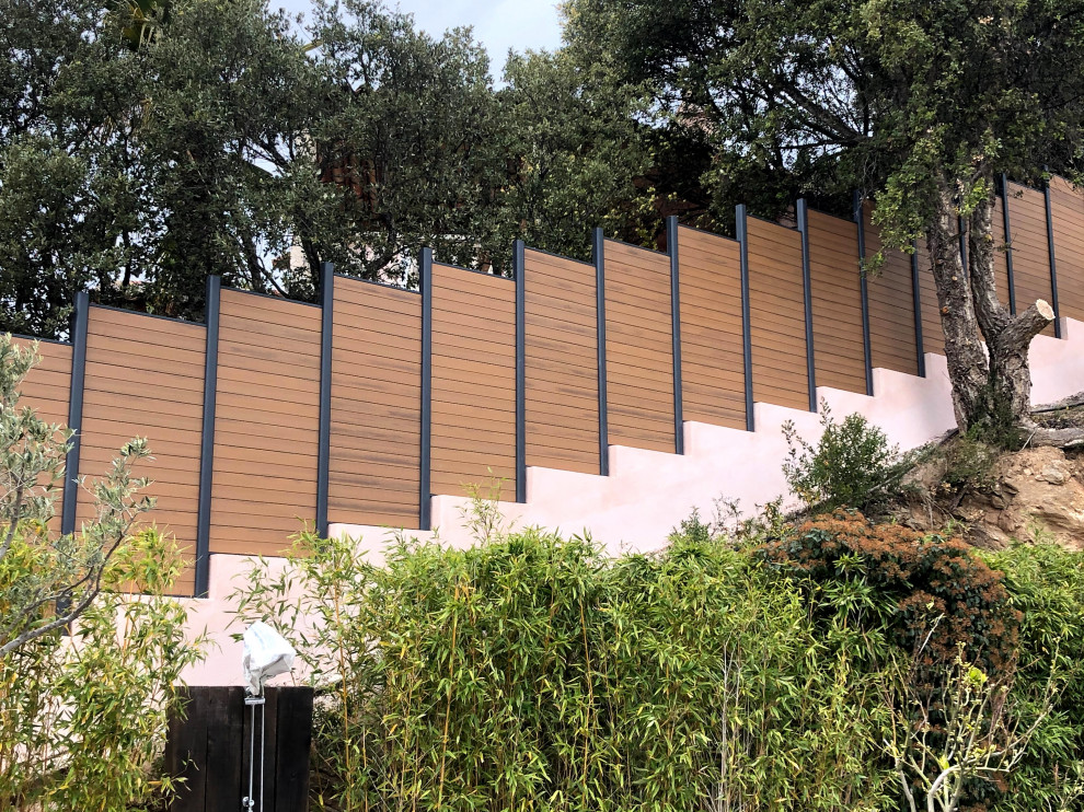 Photo of a mid-sized contemporary full sun hillside wood fence lawn edging in Nice.