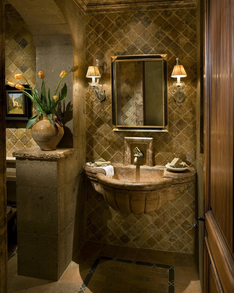 Mid-sized traditional powder room in Phoenix with beige tile, stone tile, beige walls, a wall-mount sink and beige floor.