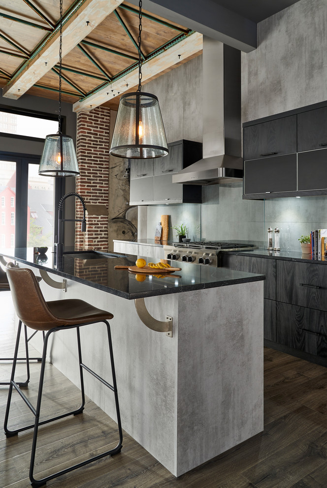 Inspiration for a mid-sized modern single-wall eat-in kitchen in New York with an undermount sink, flat-panel cabinets, black cabinets, solid surface benchtops, grey splashback, glass sheet splashback, stainless steel appliances, with island, brown floor and black benchtop.