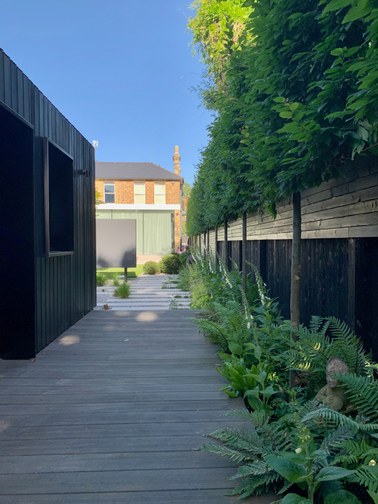 Foto di un giardino minimal esposto in pieno sole di medie dimensioni e dietro casa in estate con pavimentazioni in pietra naturale e recinzione in legno