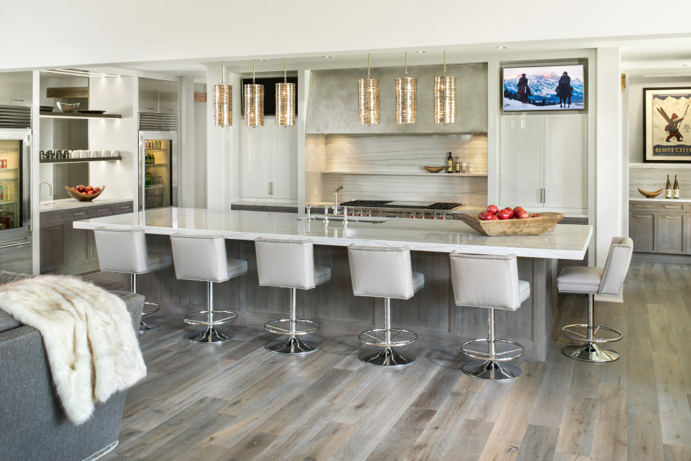 Idéer för ett stort rustikt vit kök, med en undermonterad diskho, luckor med infälld panel, grå skåp, bänkskiva i kvartsit, vitt stänkskydd, stänkskydd i sten, rostfria vitvaror, mellanmörkt trägolv, en köksö och grått golv