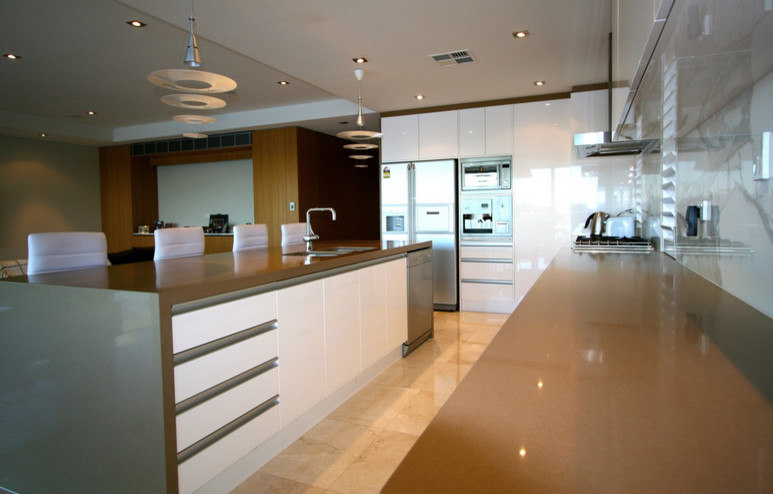 This is an example of a large contemporary l-shaped eat-in kitchen in Sydney with an undermount sink, white cabinets, quartz benchtops, white splashback, marble splashback, stainless steel appliances, marble floors, with island, beige floor and beige benchtop.