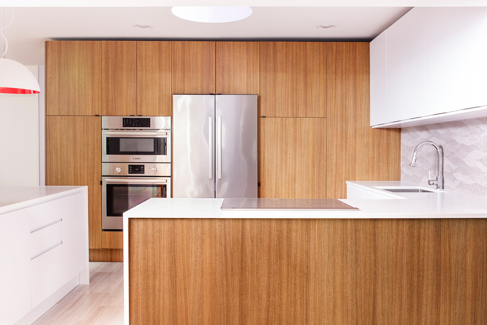 Design ideas for a small midcentury u-shaped eat-in kitchen in Philadelphia with an undermount sink, flat-panel cabinets, medium wood cabinets, solid surface benchtops, grey splashback, porcelain splashback, stainless steel appliances, porcelain floors, a peninsula and beige floor.