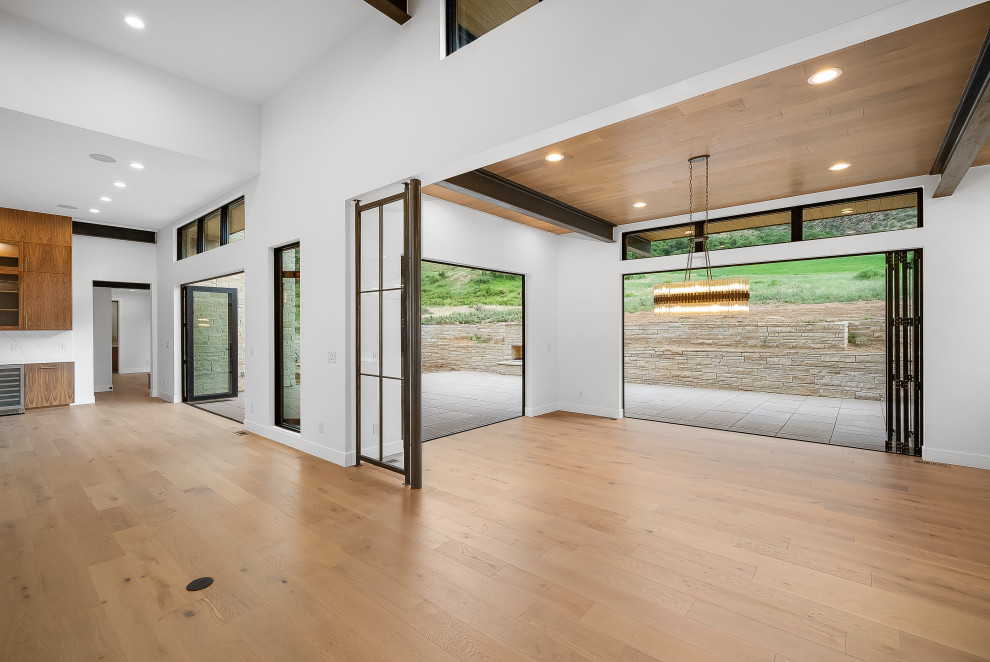 Enclosed dining room - large mid-century modern light wood floor, brown floor and exposed beam enclosed dining room idea in Denver with white walls