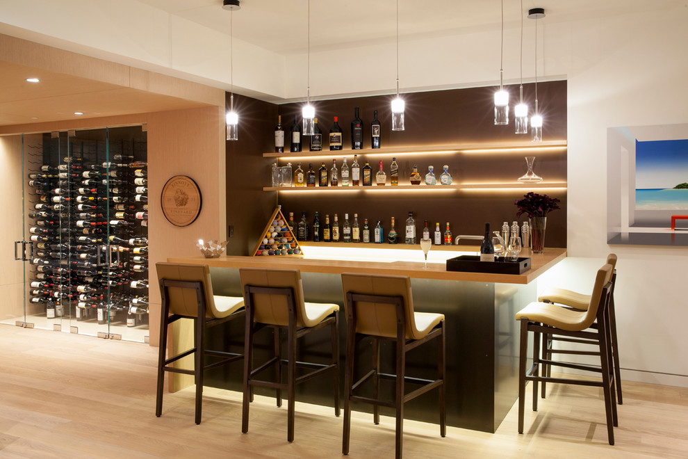 Mid-sized contemporary l-shaped seated home bar in Los Angeles with light hardwood floors, wood benchtops, brown splashback and beige floor.