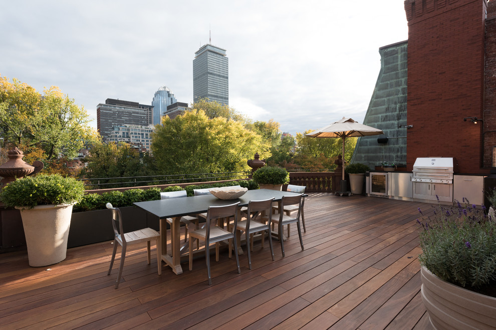 This is an example of an expansive transitional rooftop deck in Boston with an outdoor kitchen and no cover.