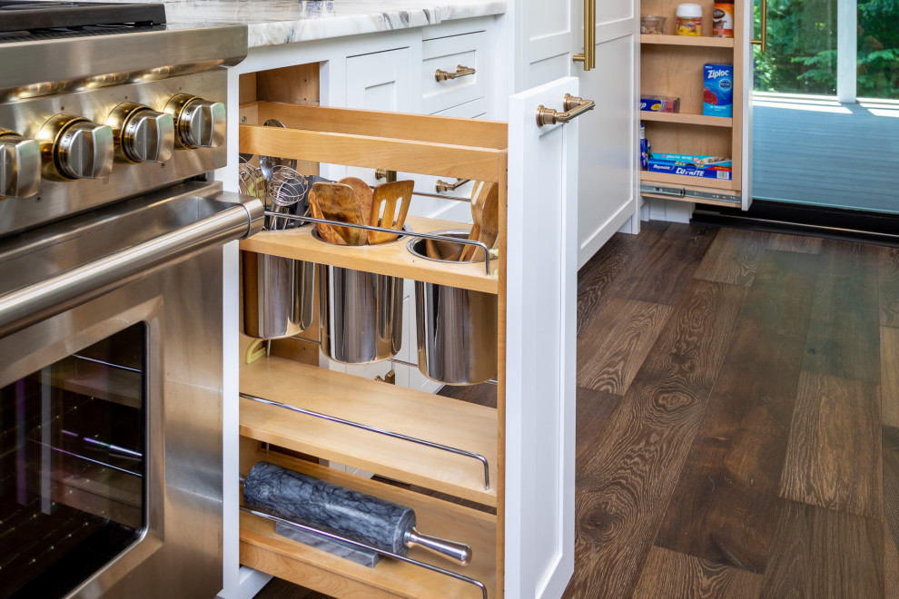 Example of a mid-sized transitional single-wall medium tone wood floor, brown floor and exposed beam open concept kitchen design in Raleigh with a single-bowl sink, shaker cabinets, white cabinets, quartzite countertops, gray backsplash, mosaic tile backsplash, paneled appliances, an island and multicolored countertops