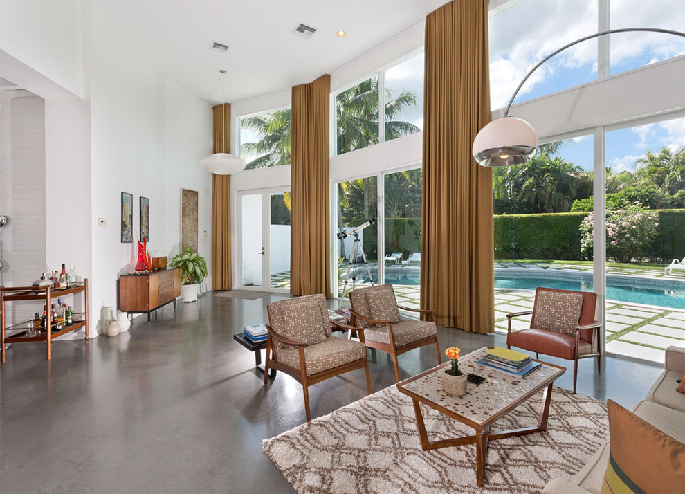 Inspiration for a mid-sized midcentury formal open concept living room in Miami with white walls, no fireplace, a concrete fireplace surround, no tv, grey floor and concrete floors.