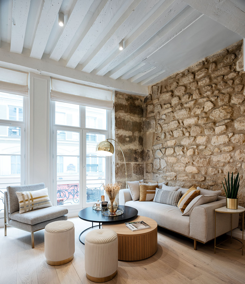 Idées déco pour un salon blanc et bois contemporain ouvert avec parquet clair, poutres apparentes et un mur en pierre.