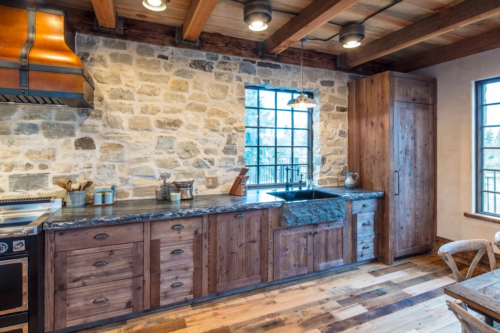Mid-sized mountain style l-shaped medium tone wood floor and brown floor open concept kitchen photo with a farmhouse sink, medium tone wood cabinets, granite countertops, paneled appliances, a peninsula and multicolored countertops