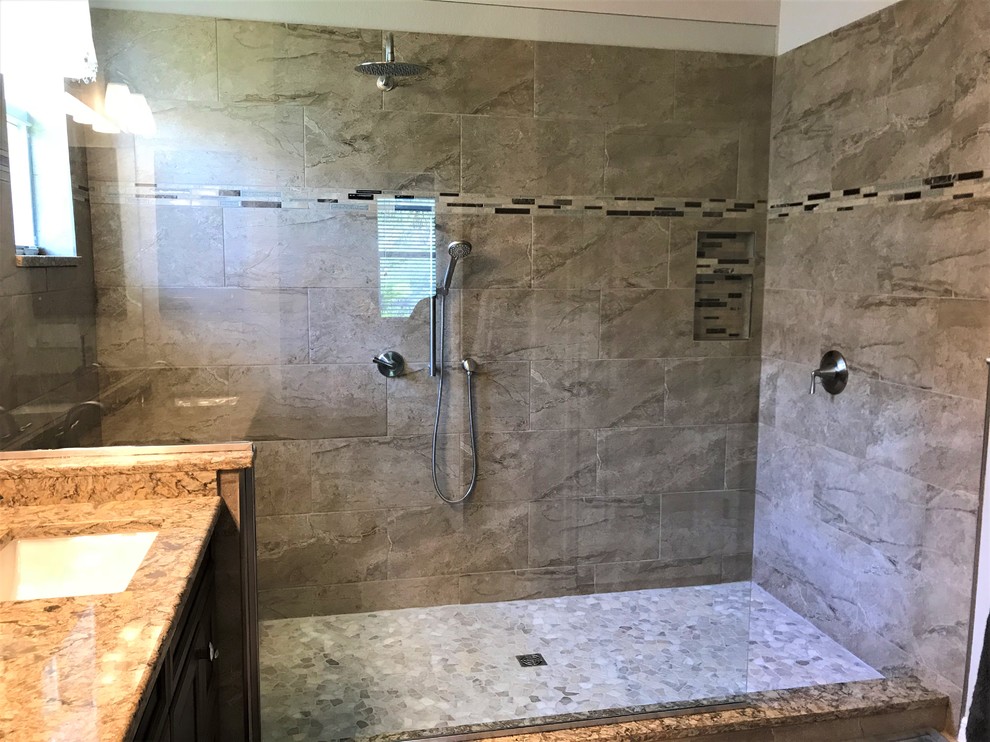 Photo of a mid-sized contemporary master bathroom in Tampa with recessed-panel cabinets, brown cabinets, beige tile, an undermount sink, engineered quartz benchtops, an open shower and multi-coloured benchtops.