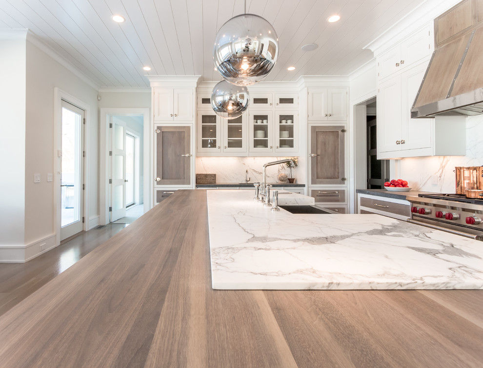 Inspiration for a large beach style l-shaped kitchen in Other with a farmhouse sink, white splashback, stainless steel appliances, light hardwood floors and with island.