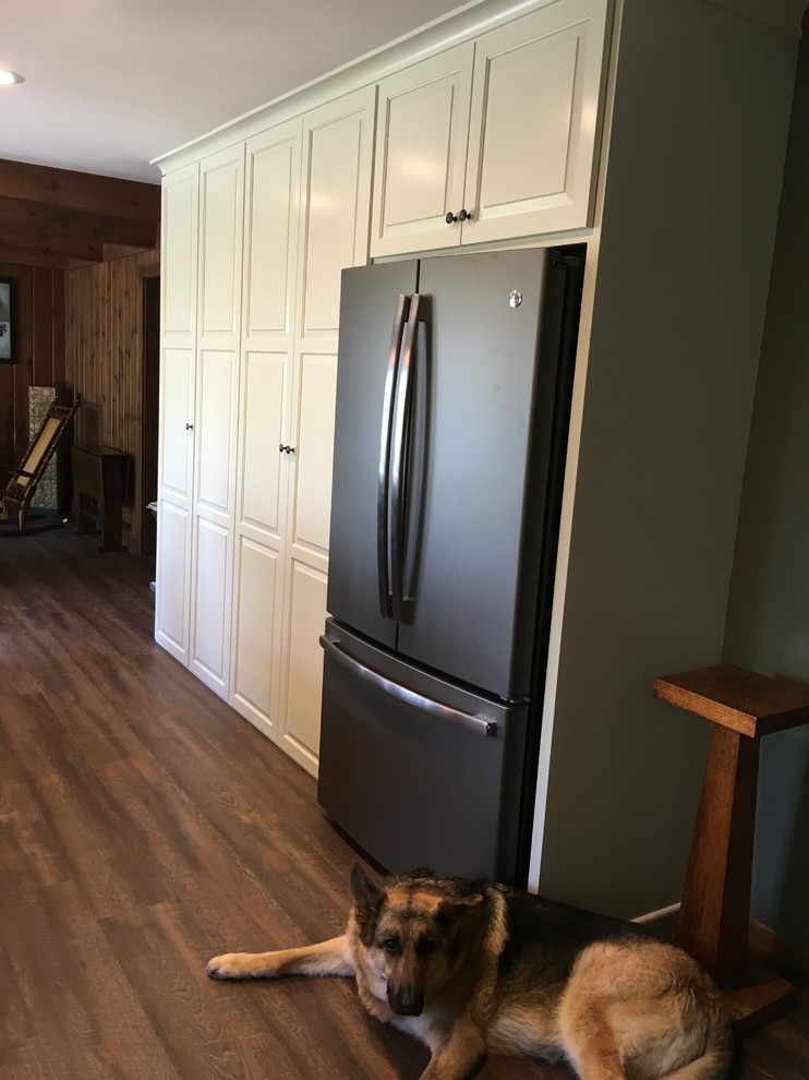 Example of a large transitional u-shaped open concept kitchen design with an undermount sink, raised-panel cabinets, dark wood cabinets, granite countertops, stainless steel appliances and an island