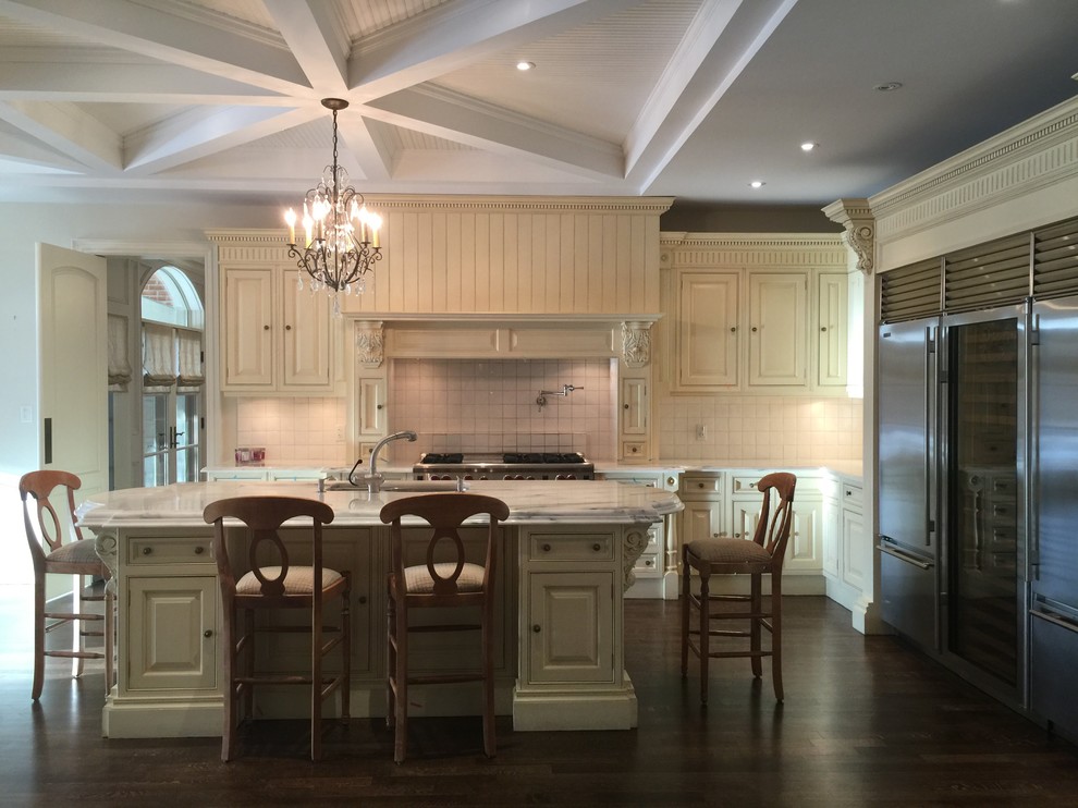 Large transitional l-shaped dark wood floor open concept kitchen photo in Toronto with a double-bowl sink, raised-panel cabinets, beige cabinets, white backsplash, stainless steel appliances and an island