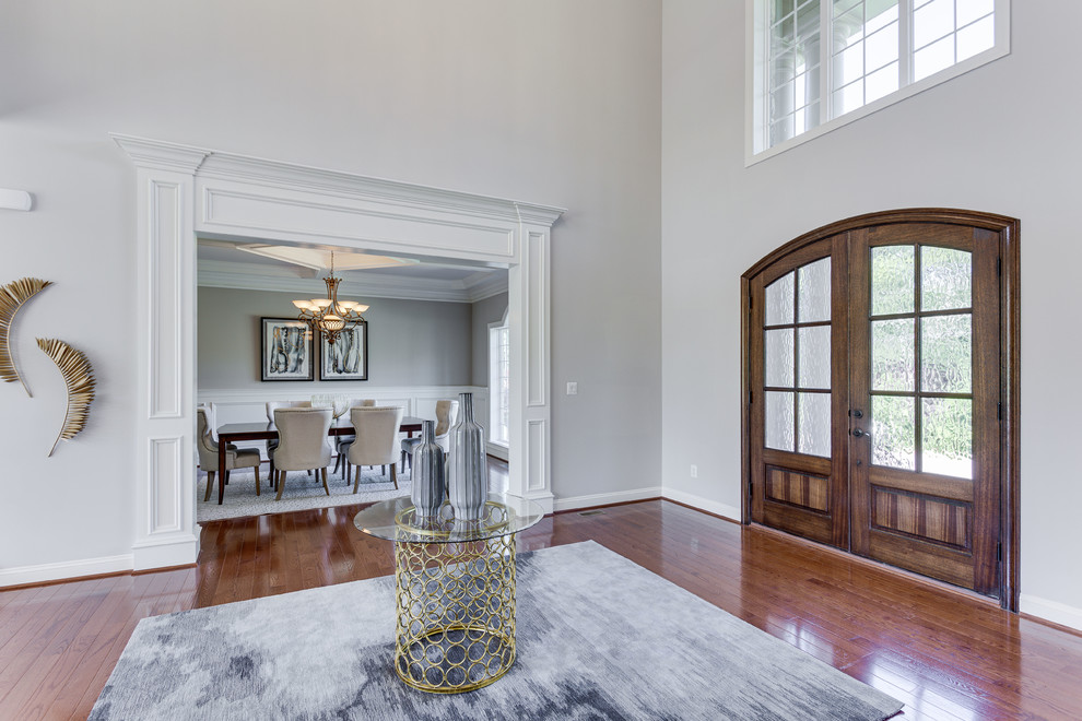 Design ideas for a traditional foyer in DC Metro with grey walls, dark hardwood floors, a double front door, a dark wood front door and brown floor.