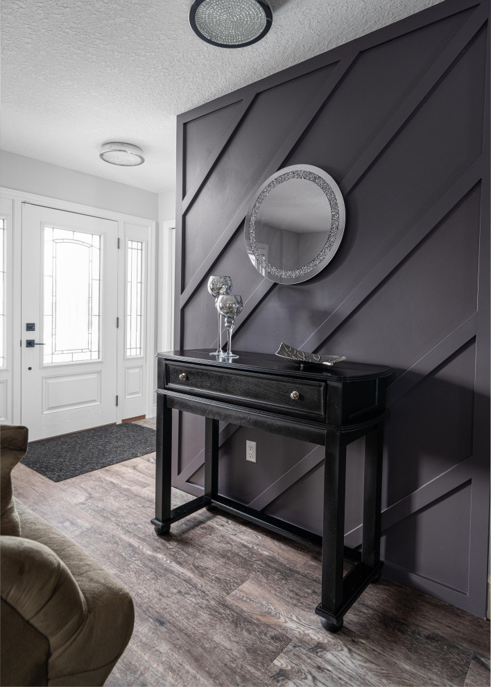 Example of a mid-sized transitional dark wood floor, brown floor and wall paneling single front door design in Toronto with black walls and a white front door