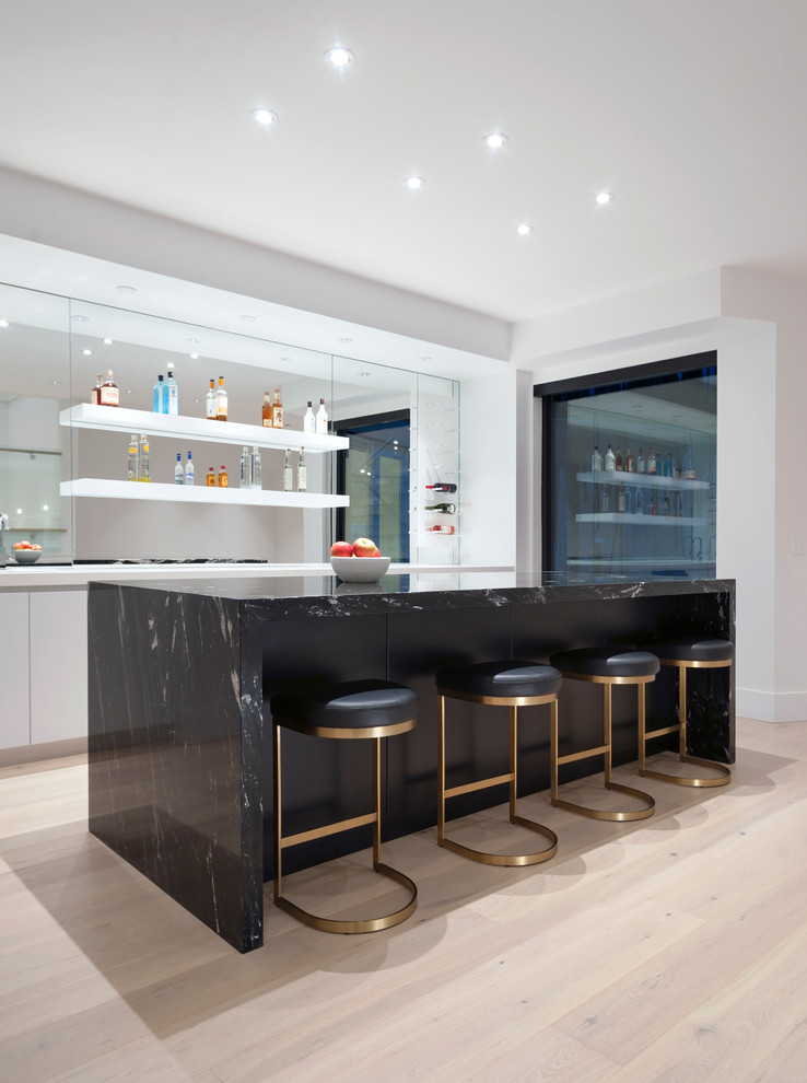 Photo of a large contemporary single-wall seated home bar in Vancouver with flat-panel cabinets, quartz benchtops, mirror splashback, grey cabinets, light hardwood floors, beige floor and black benchtop.