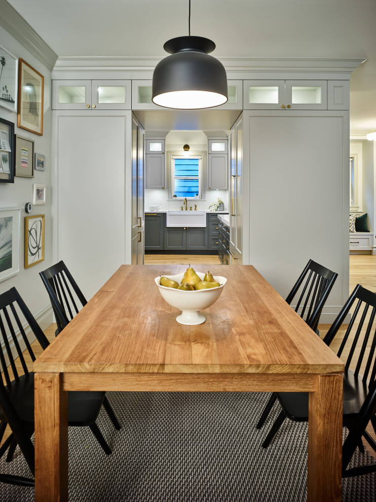 Cette photo montre une salle à manger ouverte sur la cuisine moderne de taille moyenne avec un mur gris, parquet clair et un sol marron.