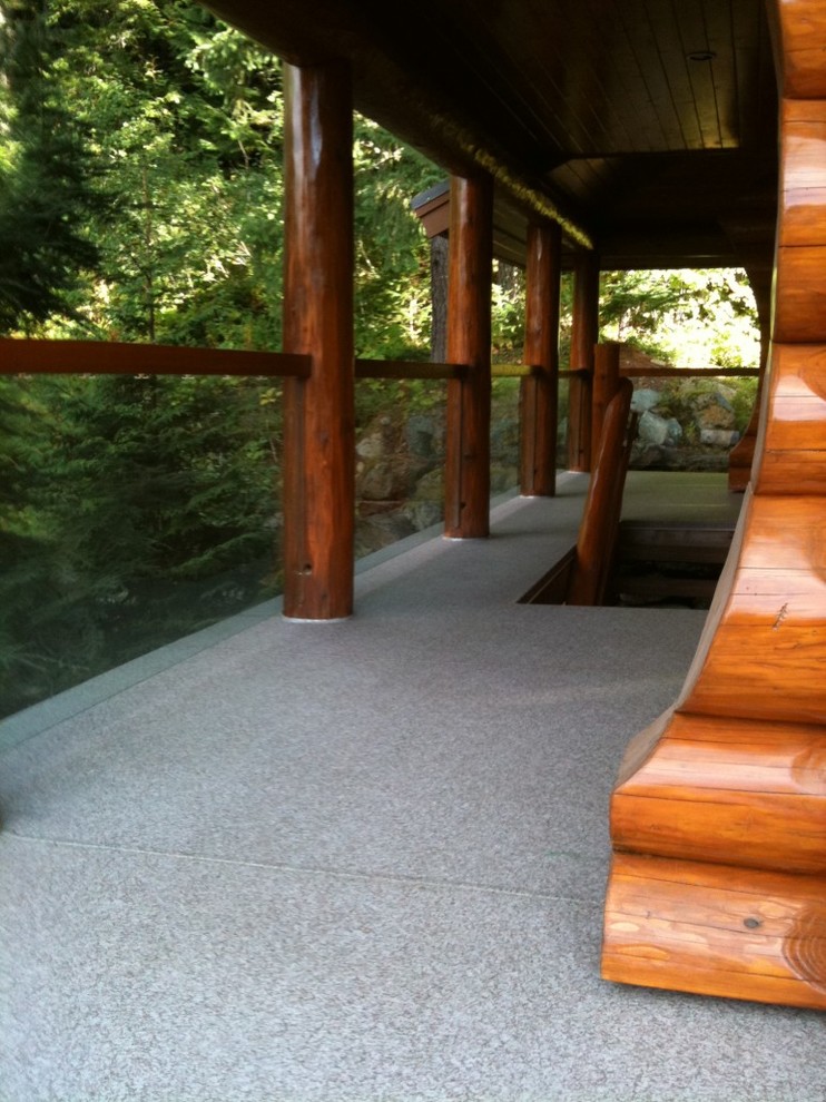 Example of a mid-sized mountain style side yard deck design in Vancouver with a roof extension