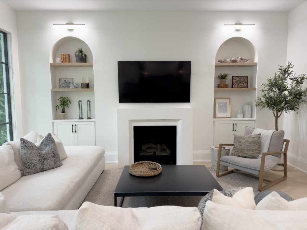 Cette photo montre un salon tendance de taille moyenne et ouvert avec un mur blanc, parquet clair, une cheminée standard, un téléviseur fixé au mur, un sol marron et un manteau de cheminée en bois.