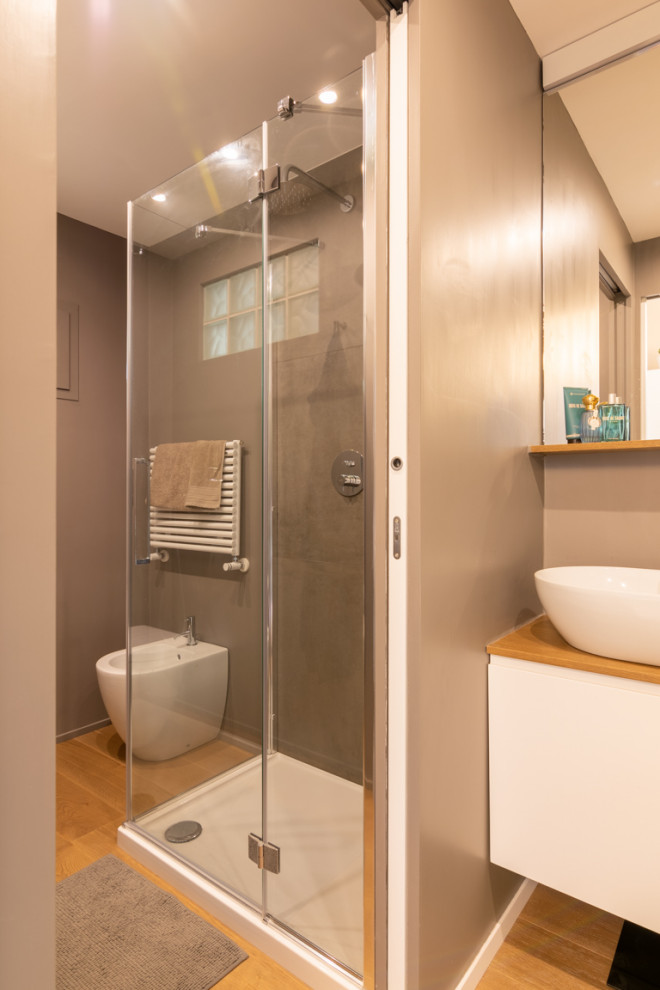 Small contemporary shower room bathroom in Other with flat-panel cabinets, white cabinets, a two-piece toilet, grey tiles, grey walls, light hardwood flooring, a vessel sink, wooden worktops, beige floors, a hinged door, beige worktops, a single sink, a built in vanity unit and a drop ceiling.