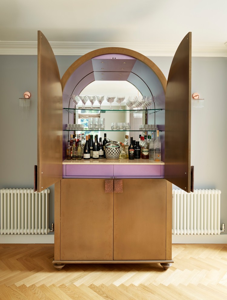 Inspiration for a contemporary home bar in London with an integrated sink, flat-panel cabinets, dark wood cabinets, granite benchtops and medium hardwood floors.