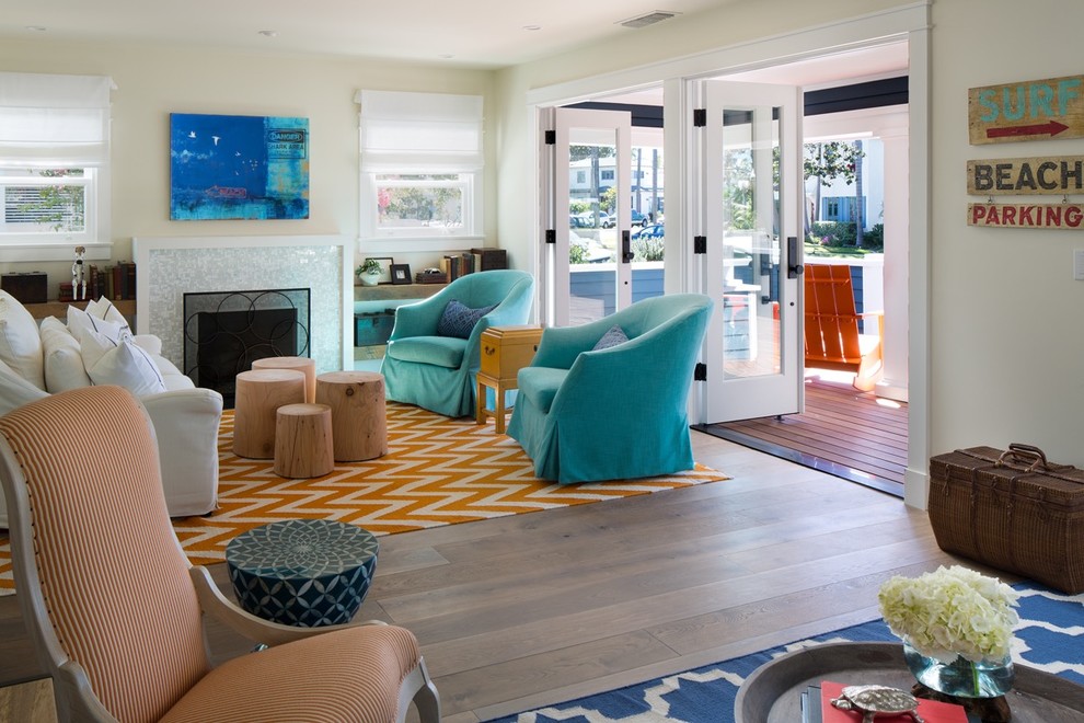 Design ideas for a beach style living room in San Diego with beige walls, medium hardwood floors, a standard fireplace and a tile fireplace surround.