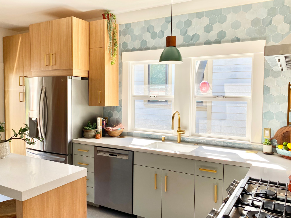 Mid-sized eclectic l-shaped kitchen in San Francisco with a single-bowl sink, flat-panel cabinets, blue cabinets, quartz benchtops, blue splashback, ceramic splashback, stainless steel appliances, concrete floors, grey floor and white benchtop.