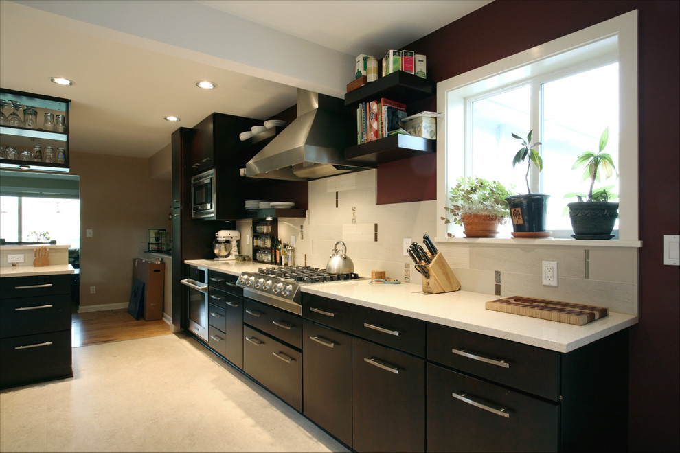 This is an example of a mid-sized contemporary kitchen in Portland with an undermount sink, flat-panel cabinets, dark wood cabinets, quartz benchtops, brown splashback, porcelain splashback and stainless steel appliances.