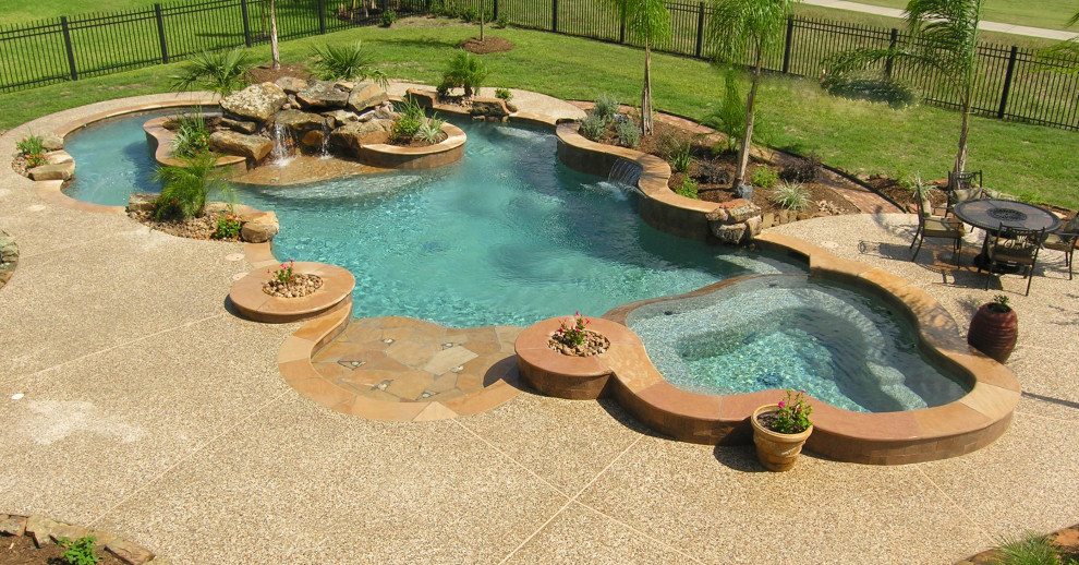 Photo of an expansive tropical backyard custom-shaped natural pool in Houston.
