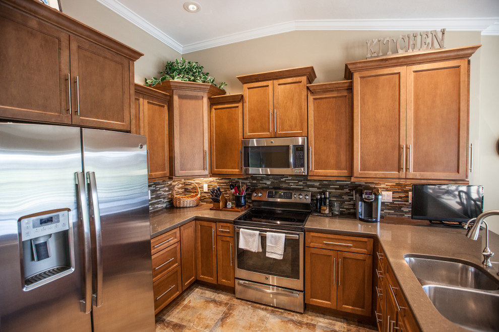 Kitchen - mid-sized u-shaped ceramic tile and vaulted ceiling kitchen idea with an undermount sink, shaker cabinets, brown cabinets, wood countertops, mosaic tile backsplash, stainless steel appliances and brown countertops