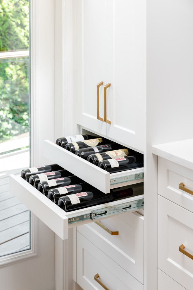 Inspiration for a large transitional l-shaped light wood floor and beige floor open concept kitchen remodel in Vancouver with an undermount sink, recessed-panel cabinets, white cabinets, quartz countertops, white backsplash, ceramic backsplash, stainless steel appliances, an island and white countertops