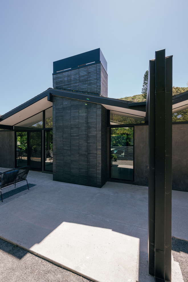 Идея дизайна: одноэтажный, кирпичный, черный частный загородный дом среднего размера в стиле ретро с двускатной крышей и крышей из смешанных материалов