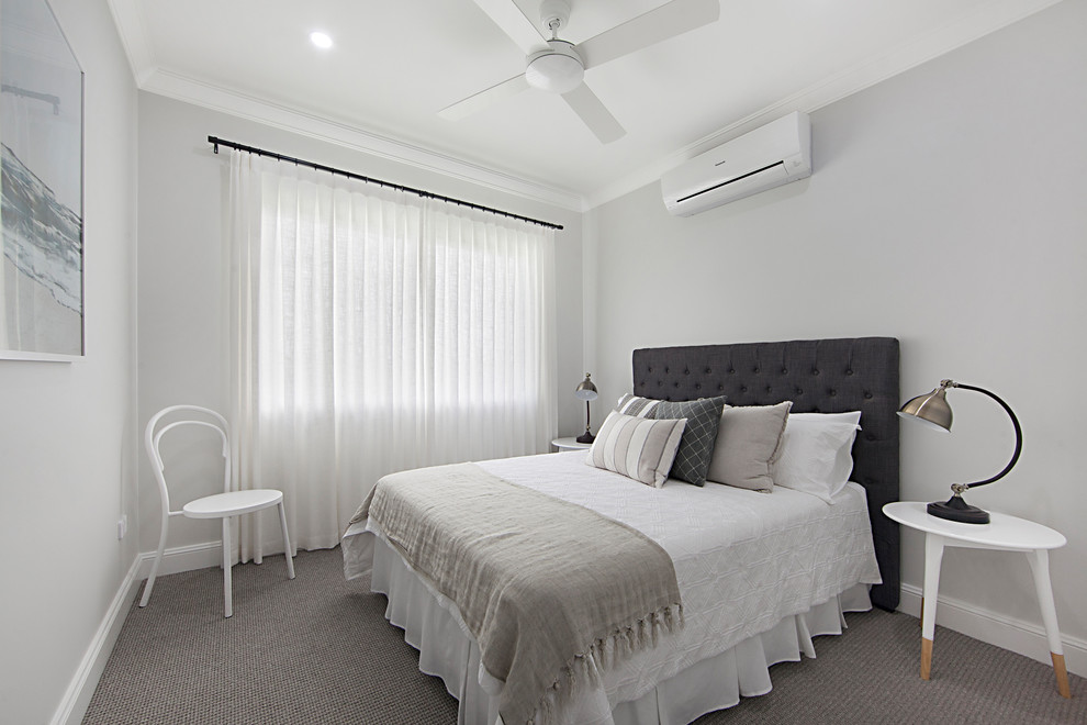 This is an example of a mid-sized transitional master bedroom in Townsville with white walls, carpet and grey floor.