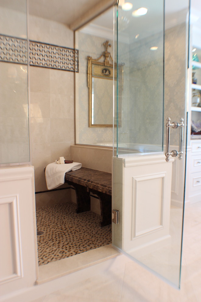 Photo of an expansive traditional master bathroom in New York with white cabinets, a corner shower, a freestanding tub, a two-piece toilet, beige tile, marble benchtops, a hinged shower door and brown benchtops.