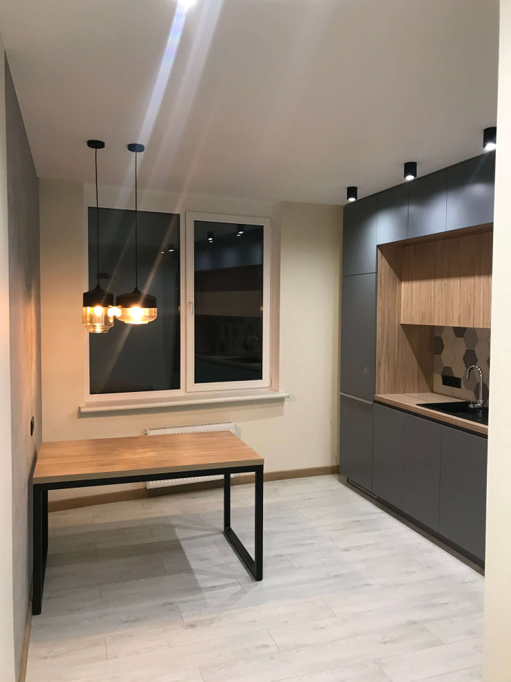 На фото: кухня-столовая среднего размера в современном стиле с серыми стенами, полом из ламината, бежевым полом и обоями на стенах без камина с