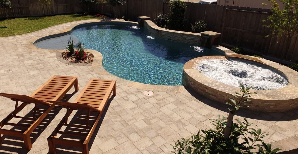 Design ideas for a mid-sized traditional backyard custom-shaped pool in Houston with a hot tub and concrete pavers.