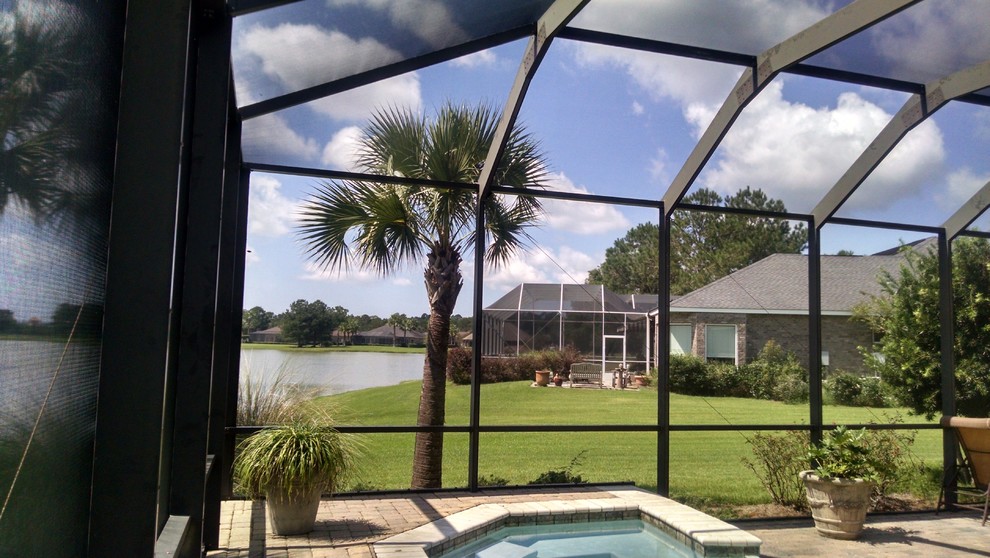 Large transitional backyard stone and custom-shaped hot tub photo in Miami